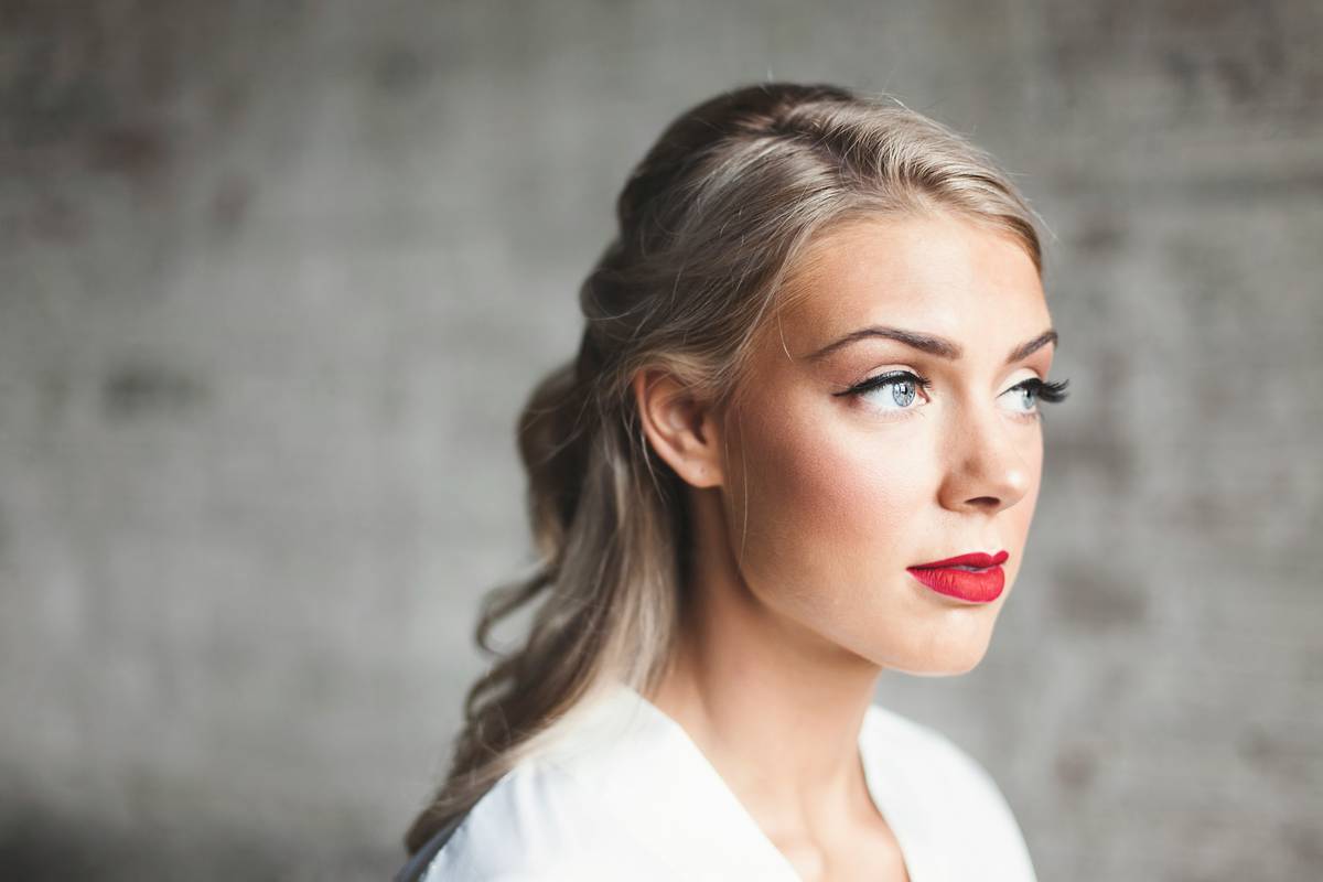 Model applying delicate makeup color with fingertip blending technique